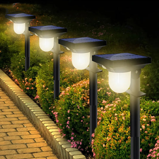 Solar-powered garden lights illuminating a pathway with flowers and greenery.