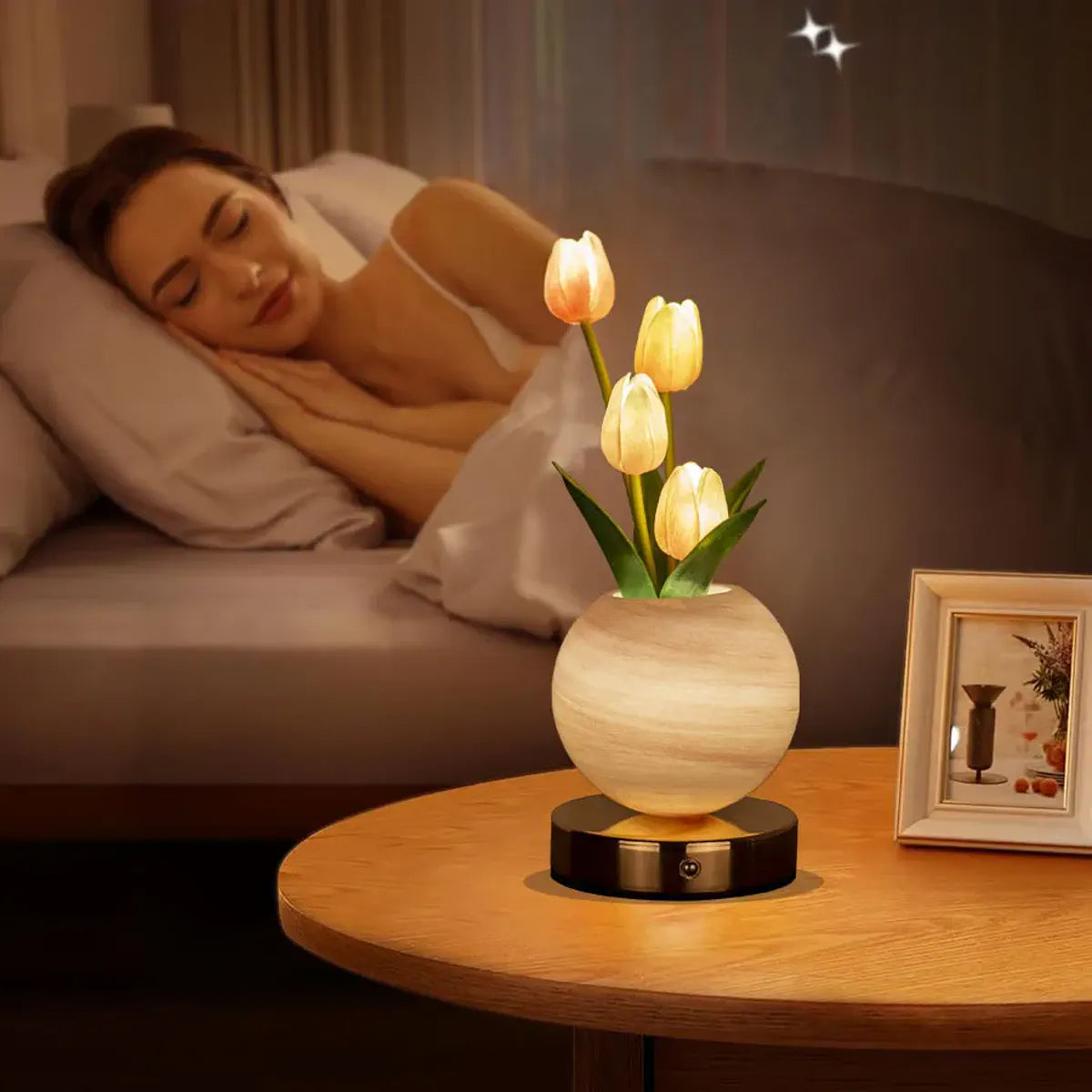 Glowing orange tulip lamp on a bedside table