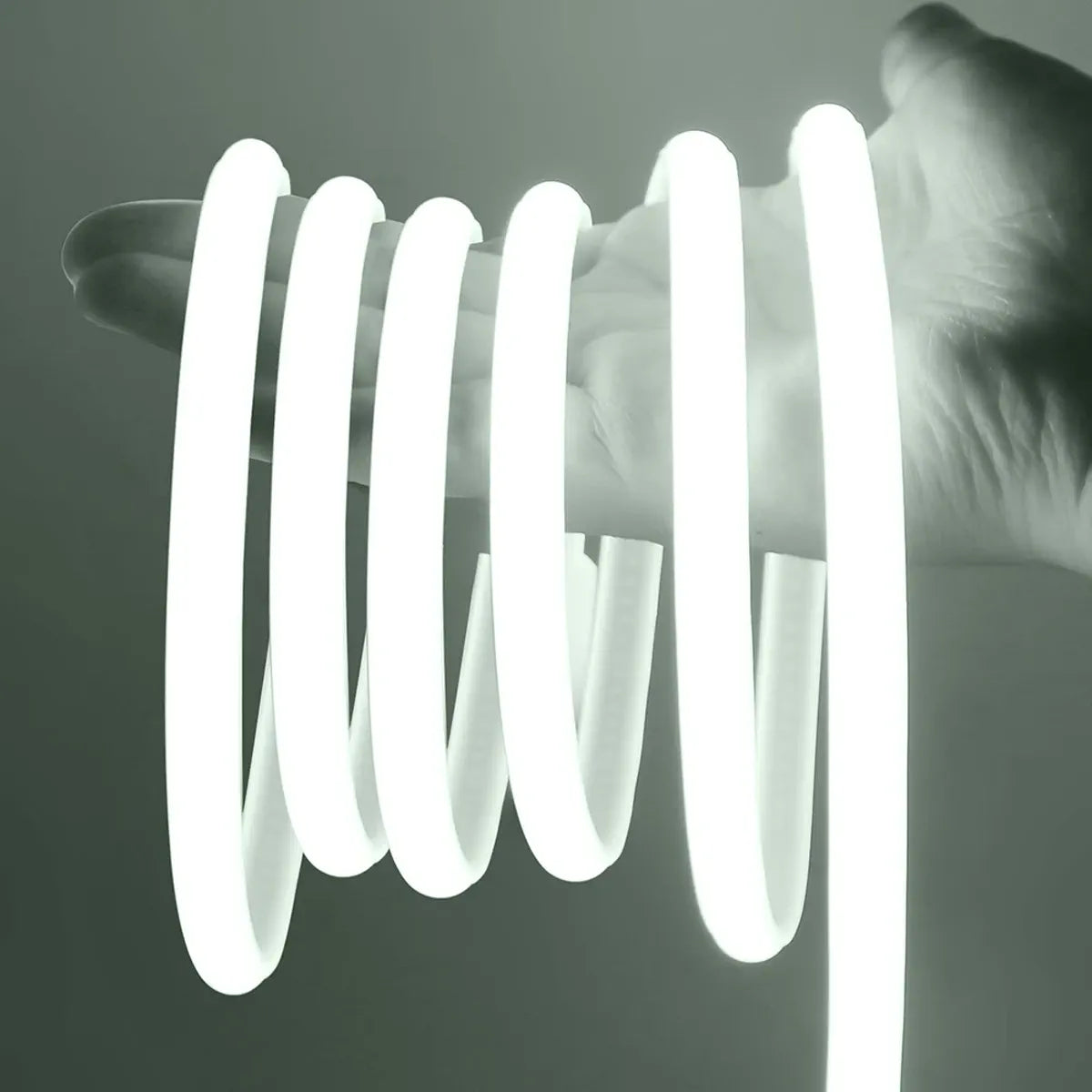 Cool white COB neon strip coiled around a hand